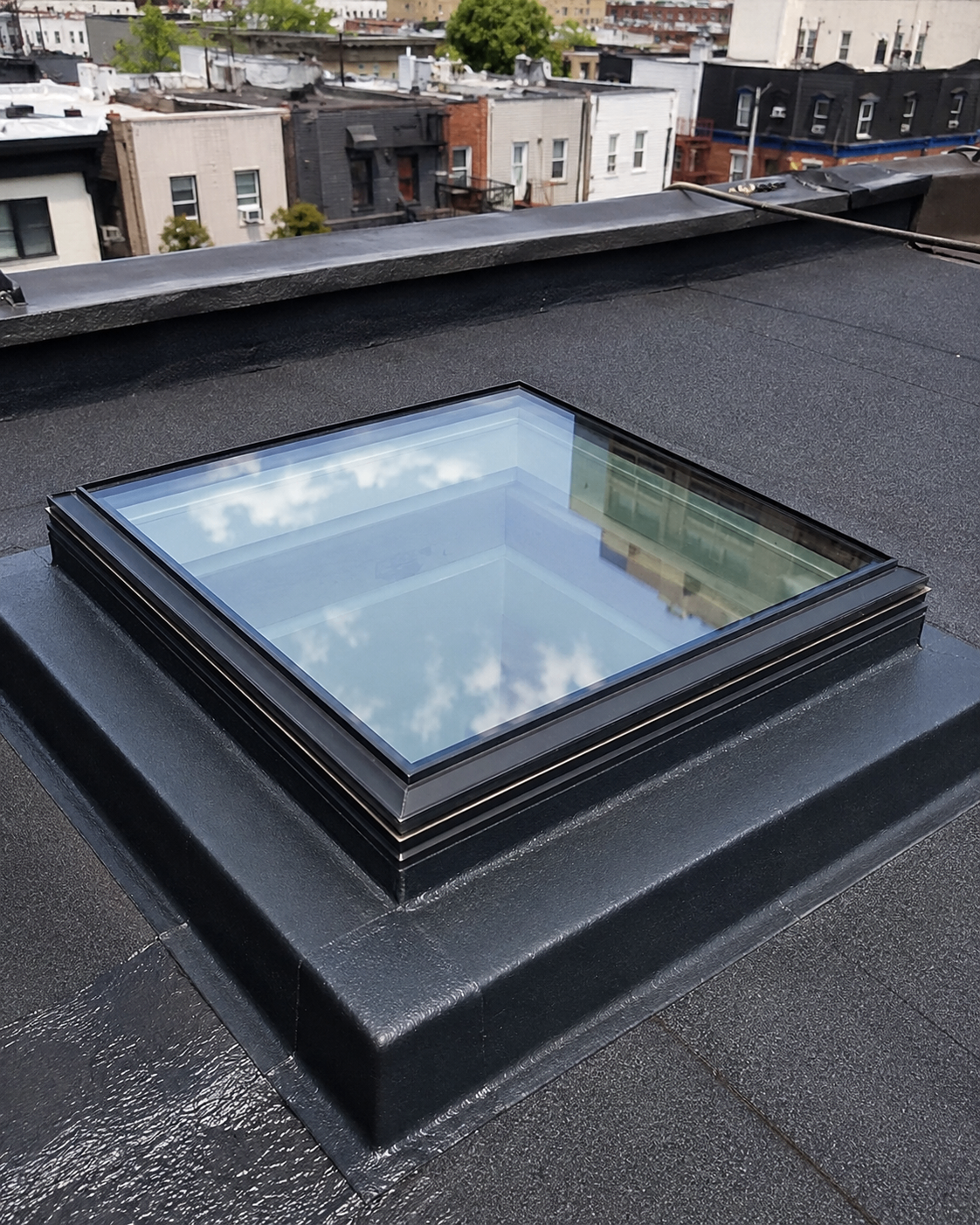 Finished flat skylight on a freshly waterproofed black roof